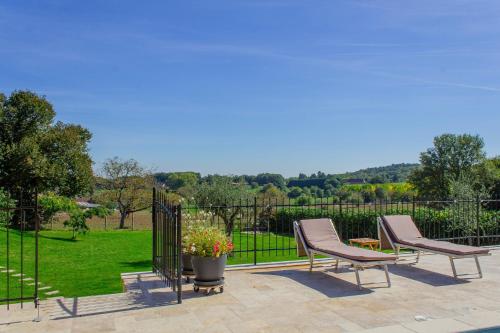 a patio with two chairs and a fence at La Mouy - Périgord Noir - Farmhouse with pool in Mauzens-et-Miremont