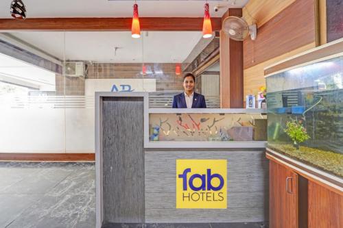 a man standing behind a counter in a restaurant at Via AB Top in Coimbatore