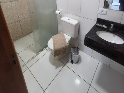 a bathroom with a toilet and a sink at Hotel Vitória - Guaíra in Guaíra