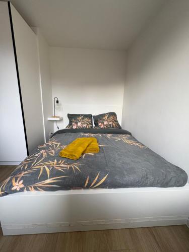 a bedroom with a bed with a yellow blanket on it at Briefstreet - Louvain in Leuven