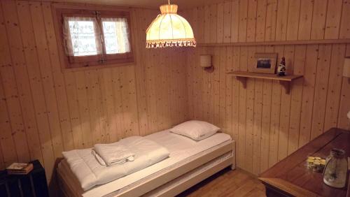 a small room with a bed in a wooden wall at Chalet Ecureuil à Champoussin - Portes du Soleil in Champoussin