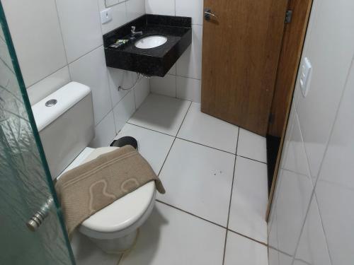 a small bathroom with a toilet and a sink at Hotel Vitória - Guaíra in Guaíra
