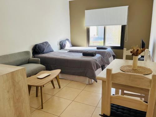 un salon avec un lit et un canapé dans l'établissement Champa Apart Pilar - EXCELENTE UBICACIÓN EN PILAR, à Pilar