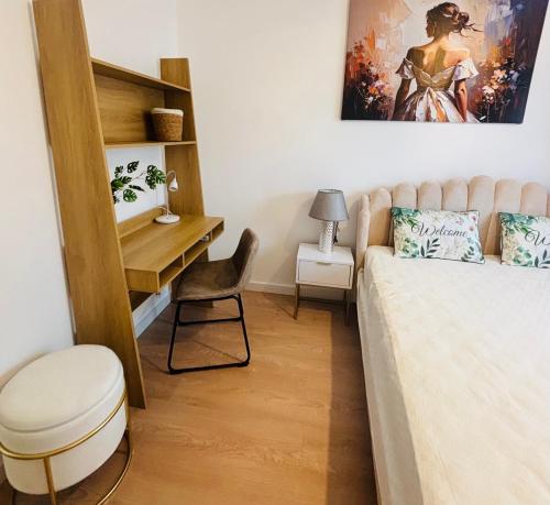 a bedroom with a bed and a desk and a chair at Lotus Apartments Impero separate kitchen two rooms parking balcony in Ostrołęka