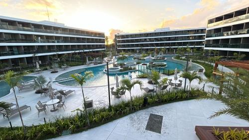 Arisch uitzicht op een resort met een zwembad en palmbomen bij Flat Beach Class Verano- Praia de Muro Alto- Porto de Galinhas in Ipojuca