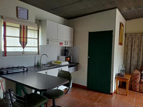 een keuken met een tafel en een groene deur bij Mooi Uitsig Droom in Beaufort West