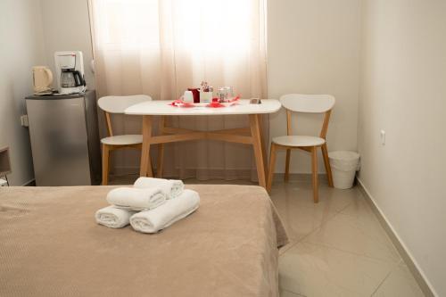 - une chambre avec une table et des serviettes sur un lit dans l'établissement Anesis Airport rooms 102, à Koropíon