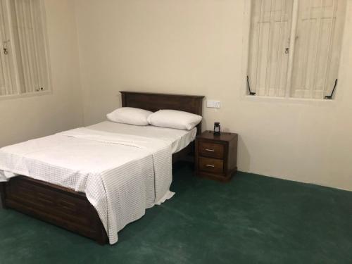 une chambre avec deux lits jumeaux et une table de chevet dans l'établissement Rathkarawwa Heights, à Haputale