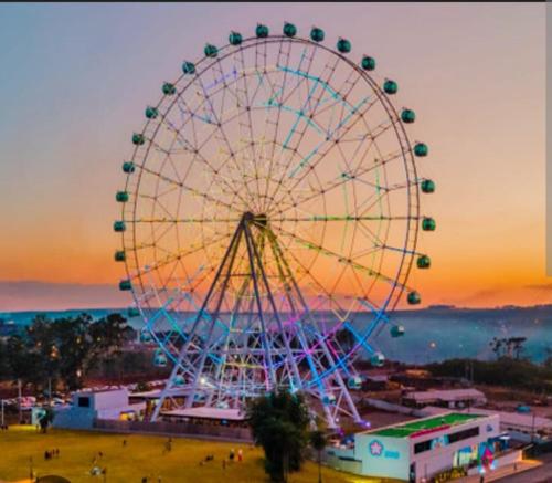 une grande roue dans un parc au coucher du soleil dans l'établissement Casa ampla e aconchegante, à Foz do Iguaçu