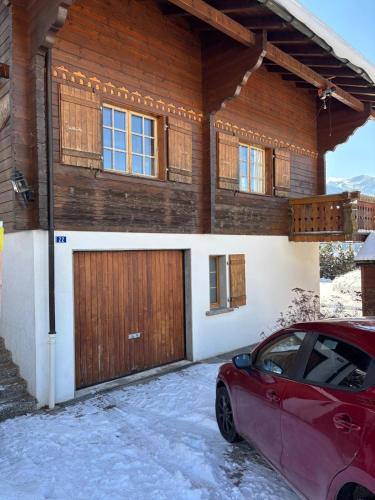 a red car parked in front of a house at Chalet familial Rose de Noël in Les Diablerets