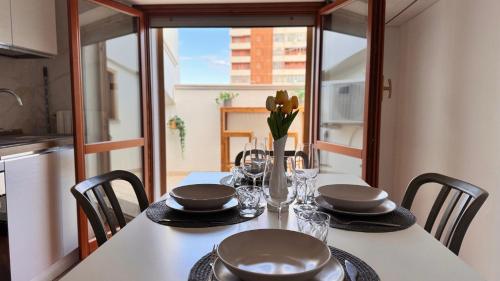 a dining room table with chairs and a table with glasses at Gioia's House in Montesilvano