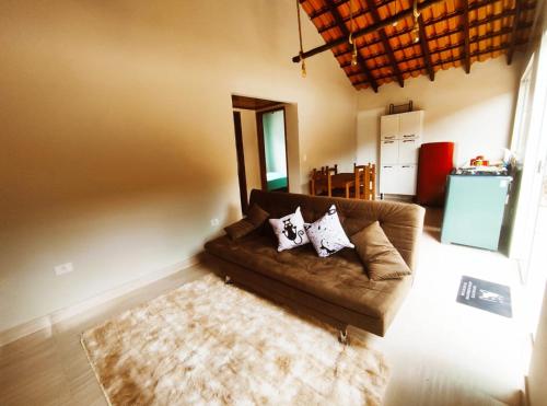 un soggiorno con divano marrone e tappeto di Canto Sereno Refúgio entre Praias e Ilhas a Parati