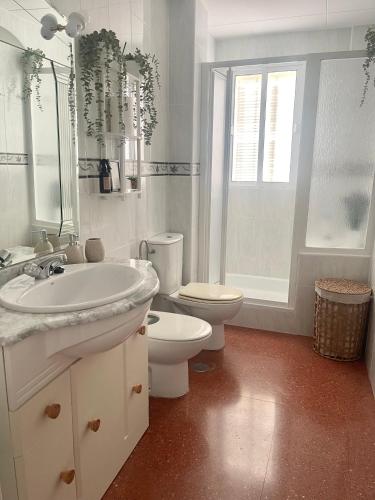 a white bathroom with a sink and a toilet at Apartamento Laurencia in Fuente Obejuna