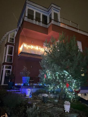 a christmas tree in front of a building at RoseHill Garden Family Villa with a Great Budapest View in Budapest