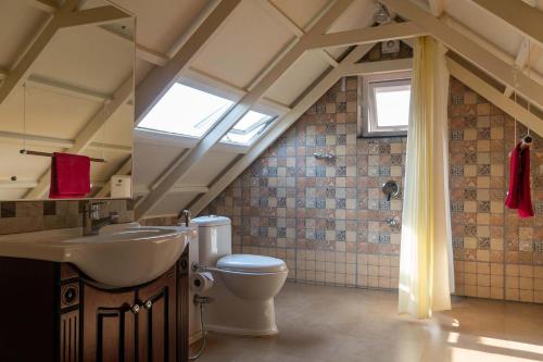 a bathroom with a toilet and a sink and a window at Yellow Tulip Luxury Villa by LexStays - Coonoor in Kolakambe