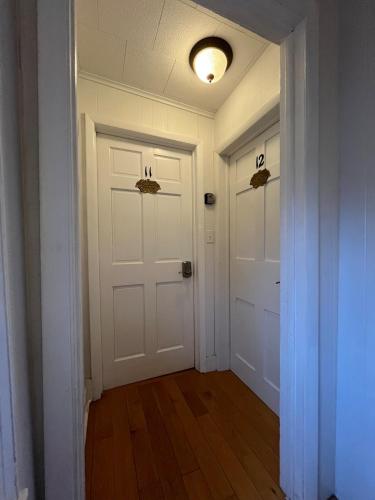 an empty hallway with two white doors and wood floors at Gulf Stream House - Hammondsport Getaway Apartment Unit 11 in Hammondsport