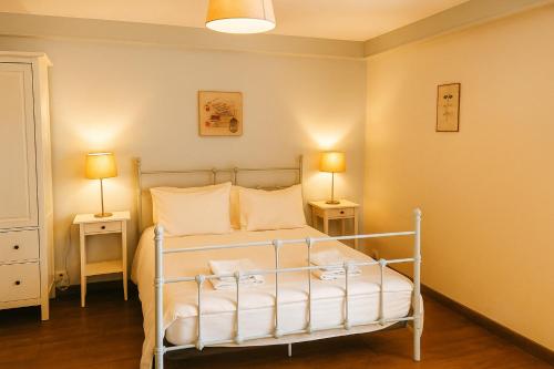 Gîte Chez Julie - Clima - Parking في سارلا لا كانيدا: غرفة نوم بها سرير ومصباحان على طاولتين