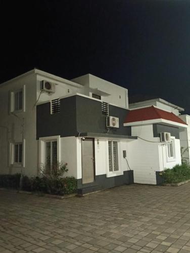 una gran casa blanca por la noche con un cielo oscuro en Vg paradise, en Covelong