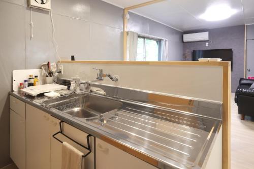 eine Küche mit Spüle und Arbeitsplatte in der Unterkunft くつろぎのお宿 やわや 駅北 in Toyama