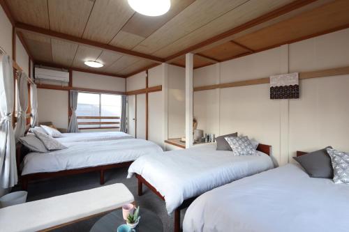 ein Zimmer mit zwei Betten und einem Fenster in der Unterkunft くつろぎのお宿 やわや 駅北 in Toyama