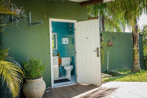 Y qué sea lo que sea في Balneario Ipora: حمام مع مرحاض في جدار أخضر