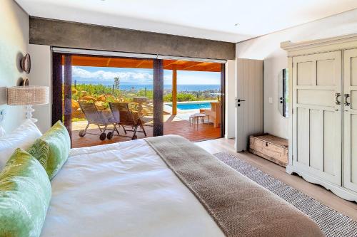 a bedroom with a bed and a view of the ocean at StonenSea in Plettenberg Bay