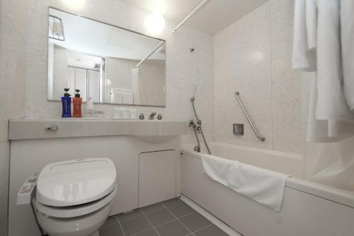 y baño blanco con aseo, lavabo y bañera. en Tendo Central Hotel, en Tendō