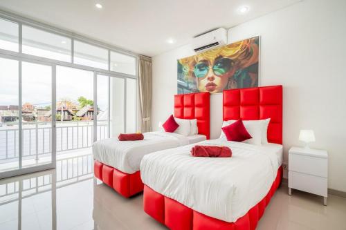 twee bedden in een kamer met een schilderij aan de muur bij Luxury minimalist villa The Toy in Kerobokan