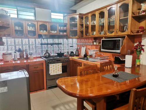 eine Küche mit einem Holztisch und einer Arbeitsfläche aus Holz in der Unterkunft La Cabaña del Tony in Villa Rica