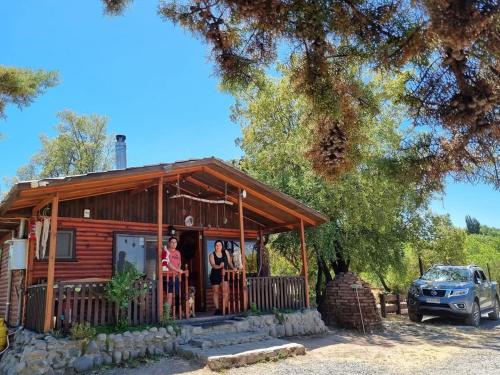 un gruppo di persone che si trova sul portico di una baita di tronchi di Centro Turístico Mayu Wasi a Los Angeles