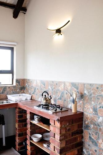 a kitchen with a brick counter top with a sink at Pecan and Lime Inn The Third Den in Pretoria