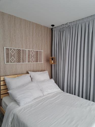 a bedroom with a bed with white sheets and a window at סיאסטה בעמק - יחידות אירוח בקיבוץ 