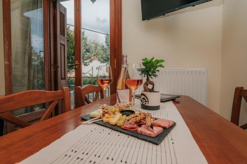 einen Teller mit Lebensmitteln auf einem Tisch mit Weingläsern in der Unterkunft Arachova Comfort in Arachova