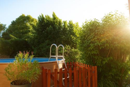 Gîte Chez Julie - Clima - Parking في سارلا لا كانيدا: سور خشبي بجانب مسبح