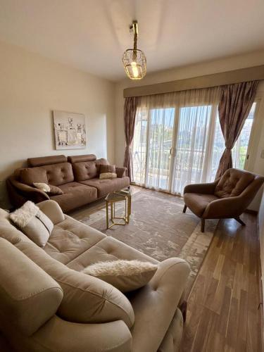 a living room with two couches and a large window at charming cozy retreat in the address compound in Sheikh Zayed