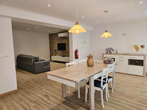 eine Küche und ein Wohnzimmer mit einem Holztisch und Stühlen in der Unterkunft Casa Trevo de 4 Folhas in Furnas