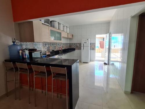 eine Küche mit schwarzer Theke und Kühlschrank in der Unterkunft Aconchego do São Francisco in Canindé de São Francisco