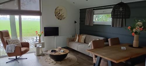 Μια τηλεόραση ή/και κέντρο ψυχαγωγίας στο FEAN nature lodge, luxe verblijf met 4 fietsen en prachtig uitzicht over de landerijen, nabij natuurgebieden Drents Friese Wold, Fochterloërveen en gevangenisdorp Veenhuizen