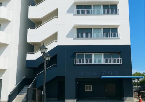 - un bâtiment bleu et blanc avec un éclairage de rue dans l'établissement Kumamoto Serviced Apartment Sakura Mee 桜美, à Kumamoto