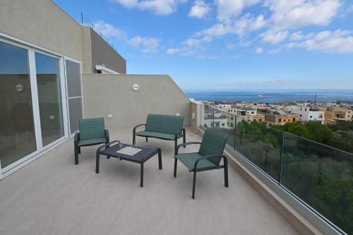 3 sedie e un tavolo sul balcone con vista di Lovely and spacious penthouse 2 bed 1 bath with wide panoramic views a Pembroke