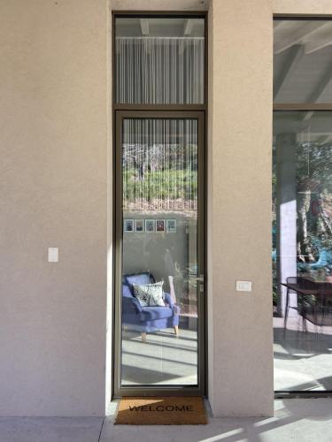 a glass door with a blue couch in a building at Terra e Lago - Holiday home in Roe
