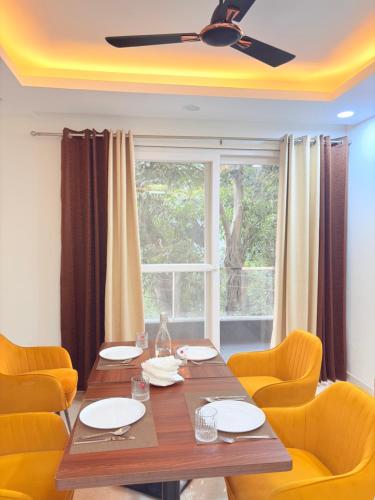 a dining room with a table and chairs and a window at The Nuvon Residency CR Park in New Delhi