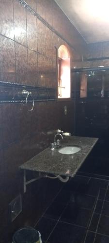 贝洛奥里藏特Casa aconchegante的带水槽和窗户的浴室