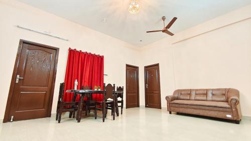 a living room with a couch and a table and chairs at 10 mins to Rock Beach-Sérénade Homestay in Puducherry