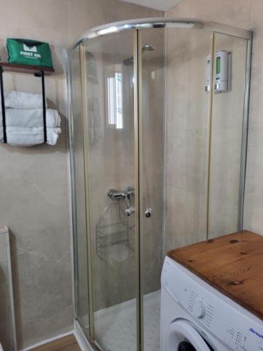 une cabine de douche dans une salle de bain avec une machine à laver dans l'établissement Apartamento delfin verde, à Benalmádena