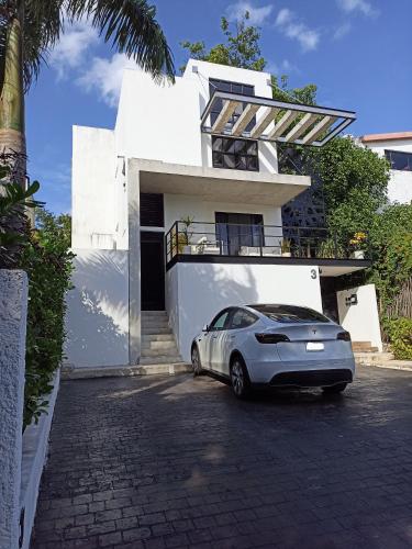 a car parked in front of a white house at TR3S by Walter de la Renta in Cancún
