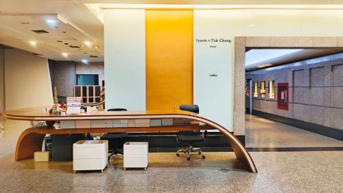 een kantoor met een bureau en stoelen in de lobby bij Iyarin @ Tuk Chang Hotel in Bangkok