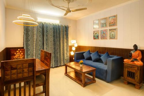 a living room with a blue couch and a table at Meera Homes - 1st floor in Dehradun