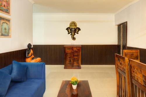 a living room with a blue couch and a mask on the wall at Meera Homes - 1st floor in Dehradun