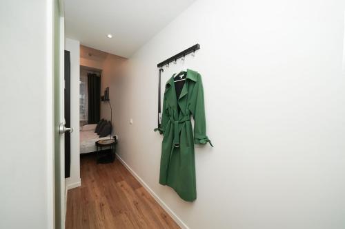a green coat hanging on a wall in a hallway at Stylish Studio in Tallinn